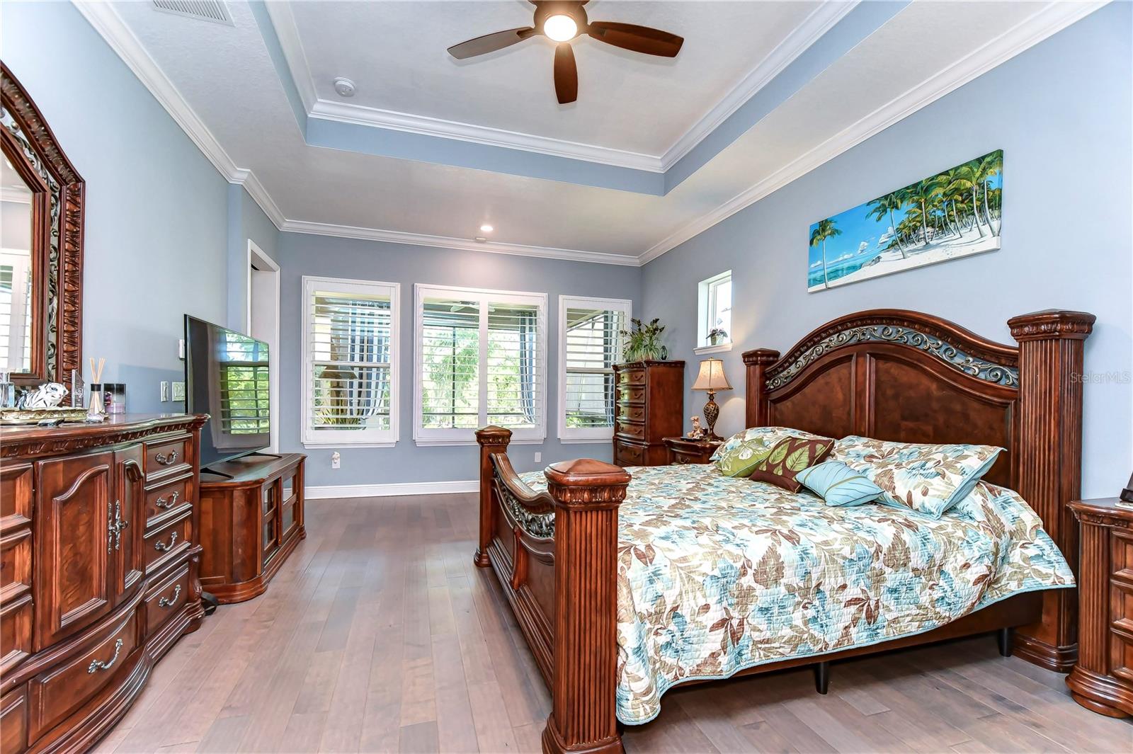 Primary suite offers plantation shutters, crown & gorgeous flooring!