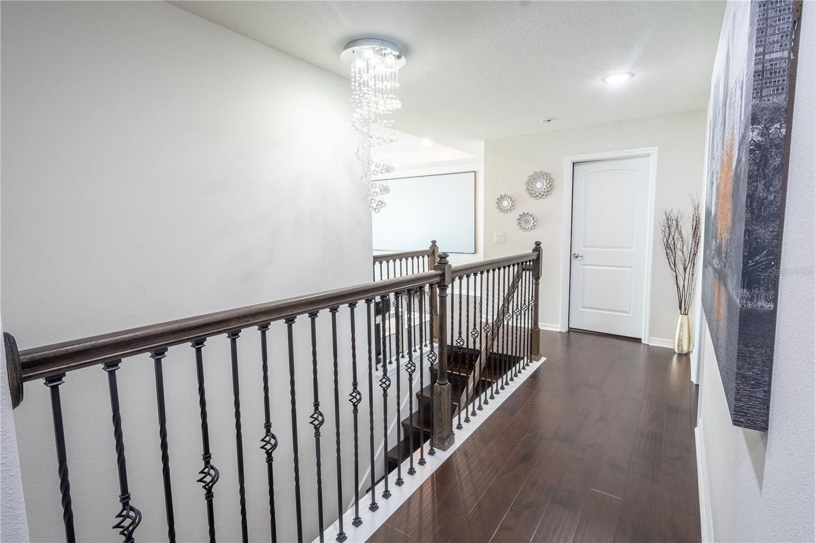 The upstairs hallway features wood laminate flooring and a Spiral Crystal Chandelier, Raindrop Pendant Light Fixture.