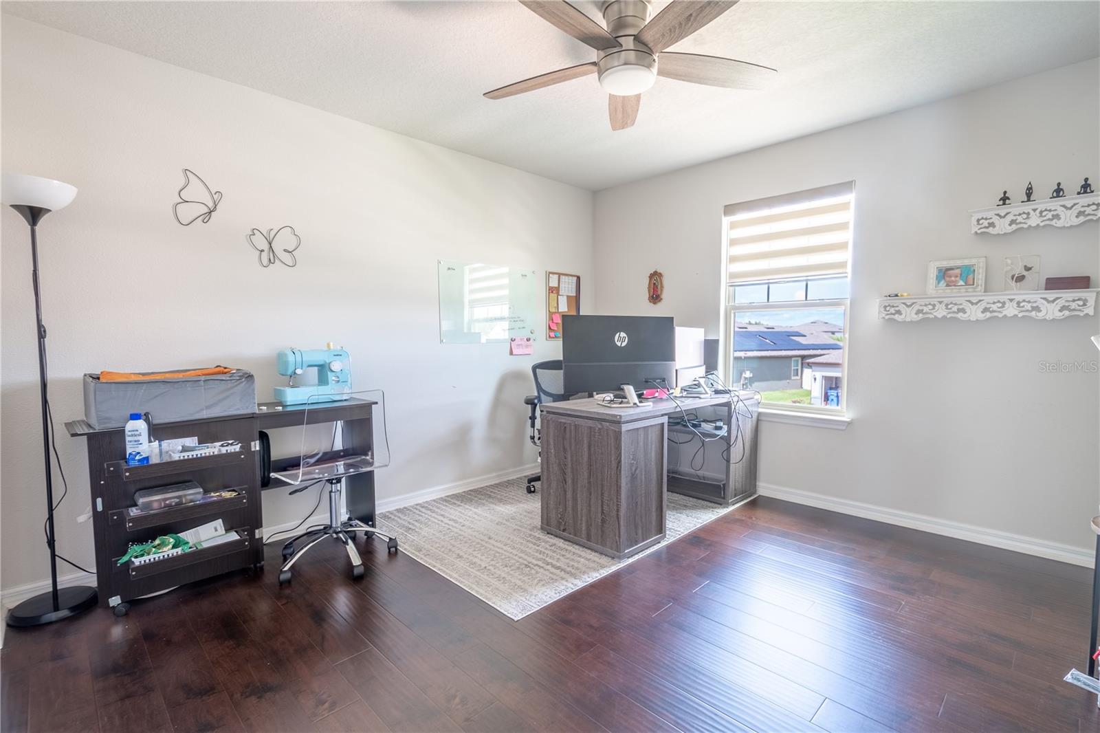 Bedroom 4 is currently used as a home office and features wood laminate flooring, a ceiling fan with light kit and a built in closet.