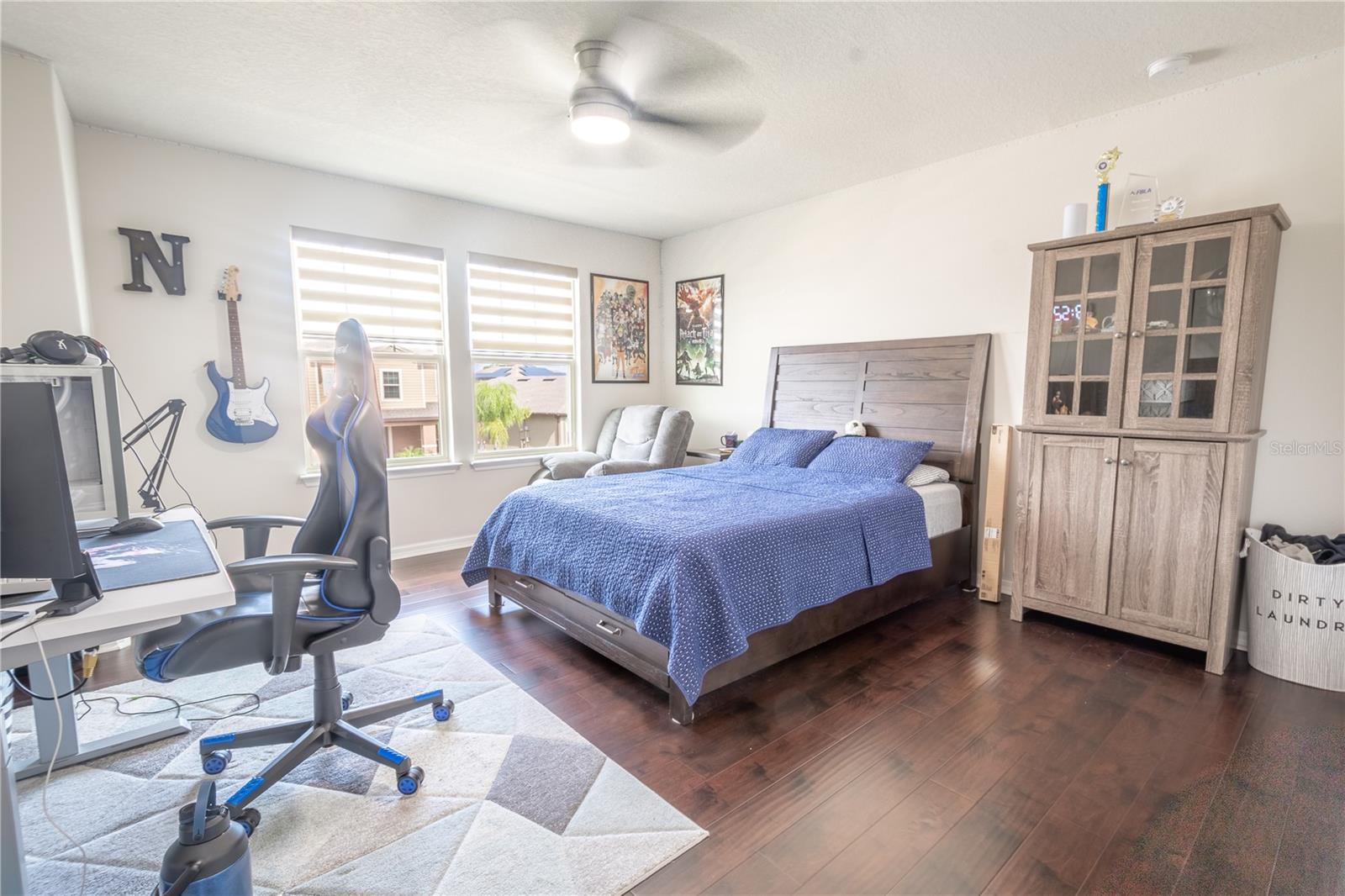 Bedroom 2 features wood laminate flooring, a ceiling fan with light kit, and a built-in closet.