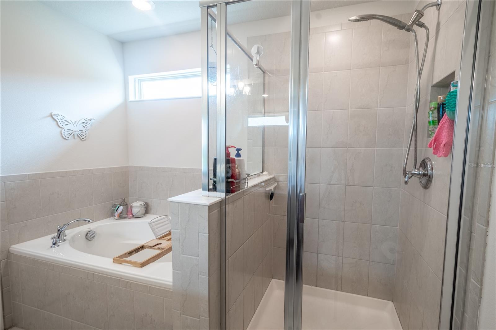 The primary bath features a separate, tiled,  walk-in shower.