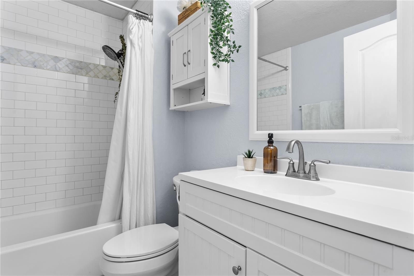 This updated bathroom with shower/tub combo is neat and elegant.