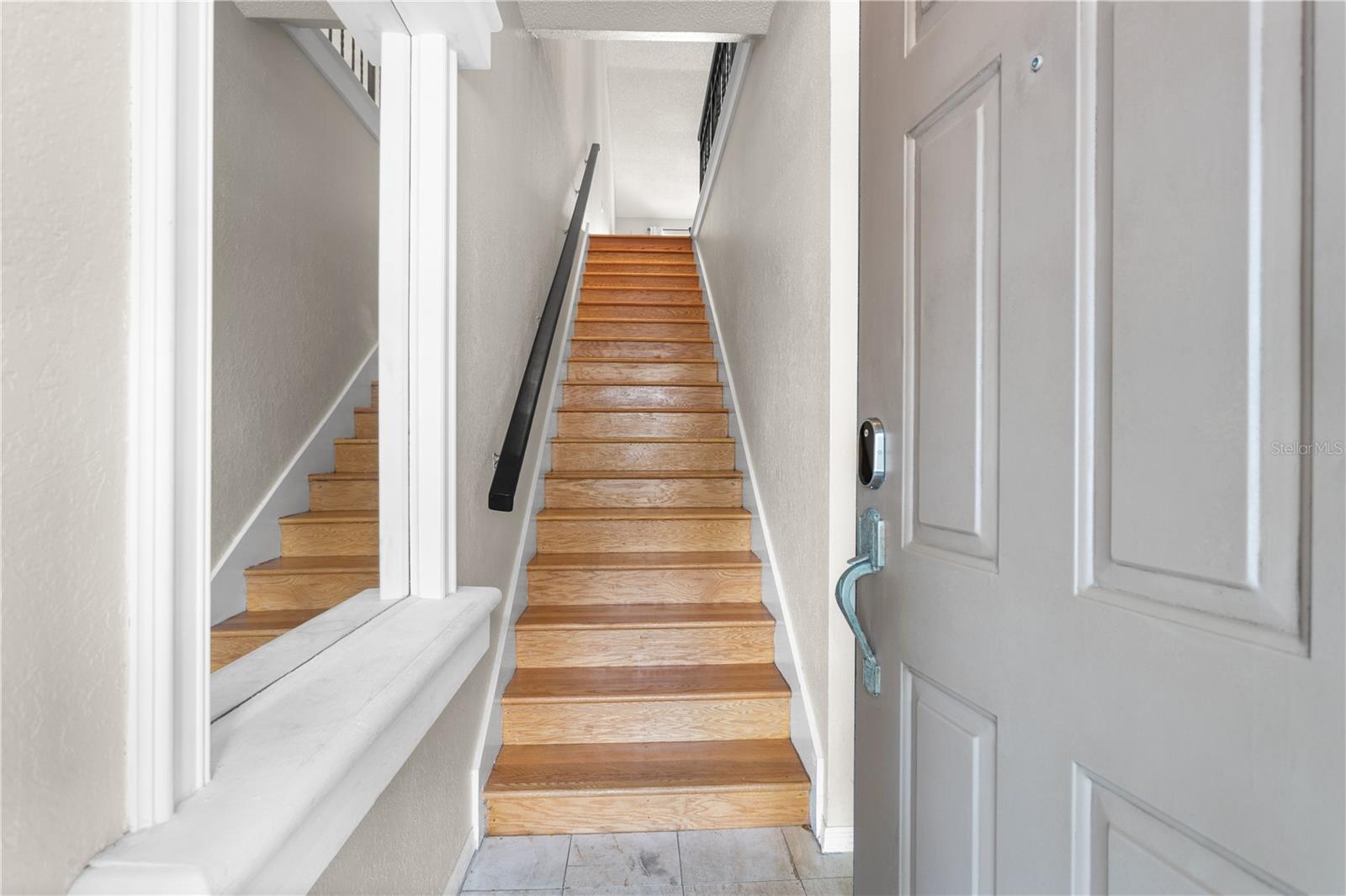 Open the door to find a nice sized foyer with beautiful wood stairs leading to the living area.