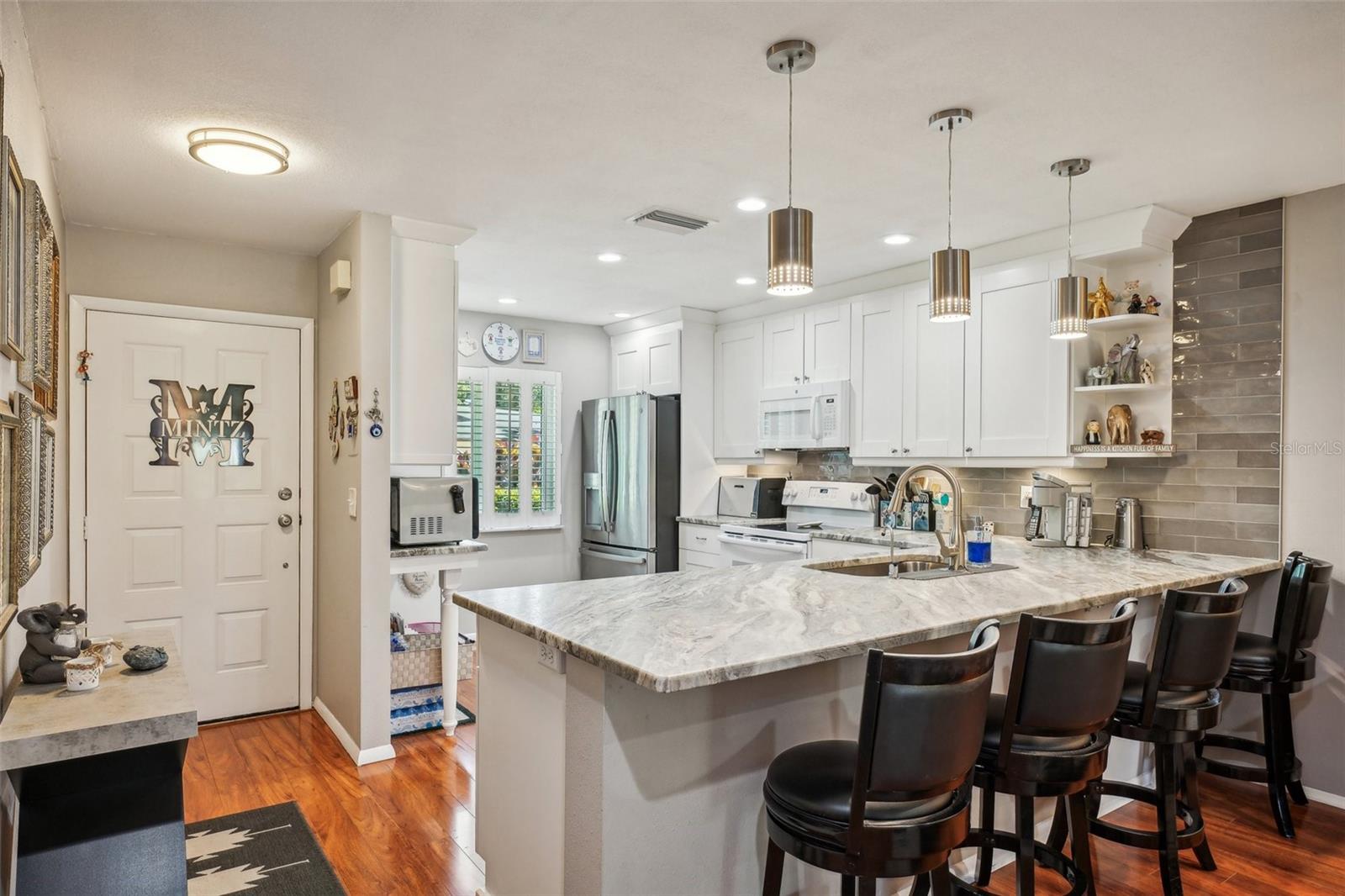 Front door leading to open concept kitchen