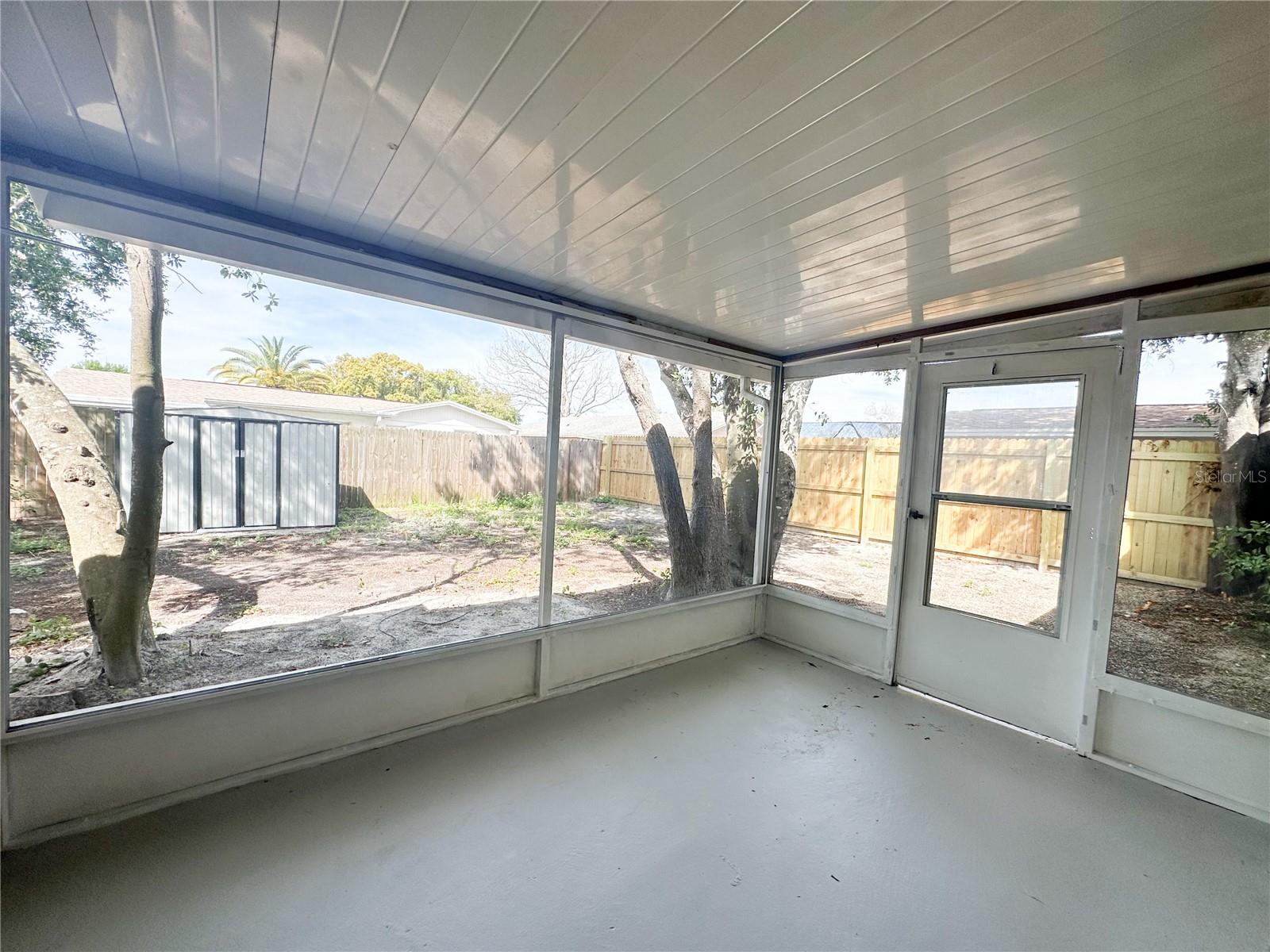 Large Screen Porch Overlooking Fenced Backyard.