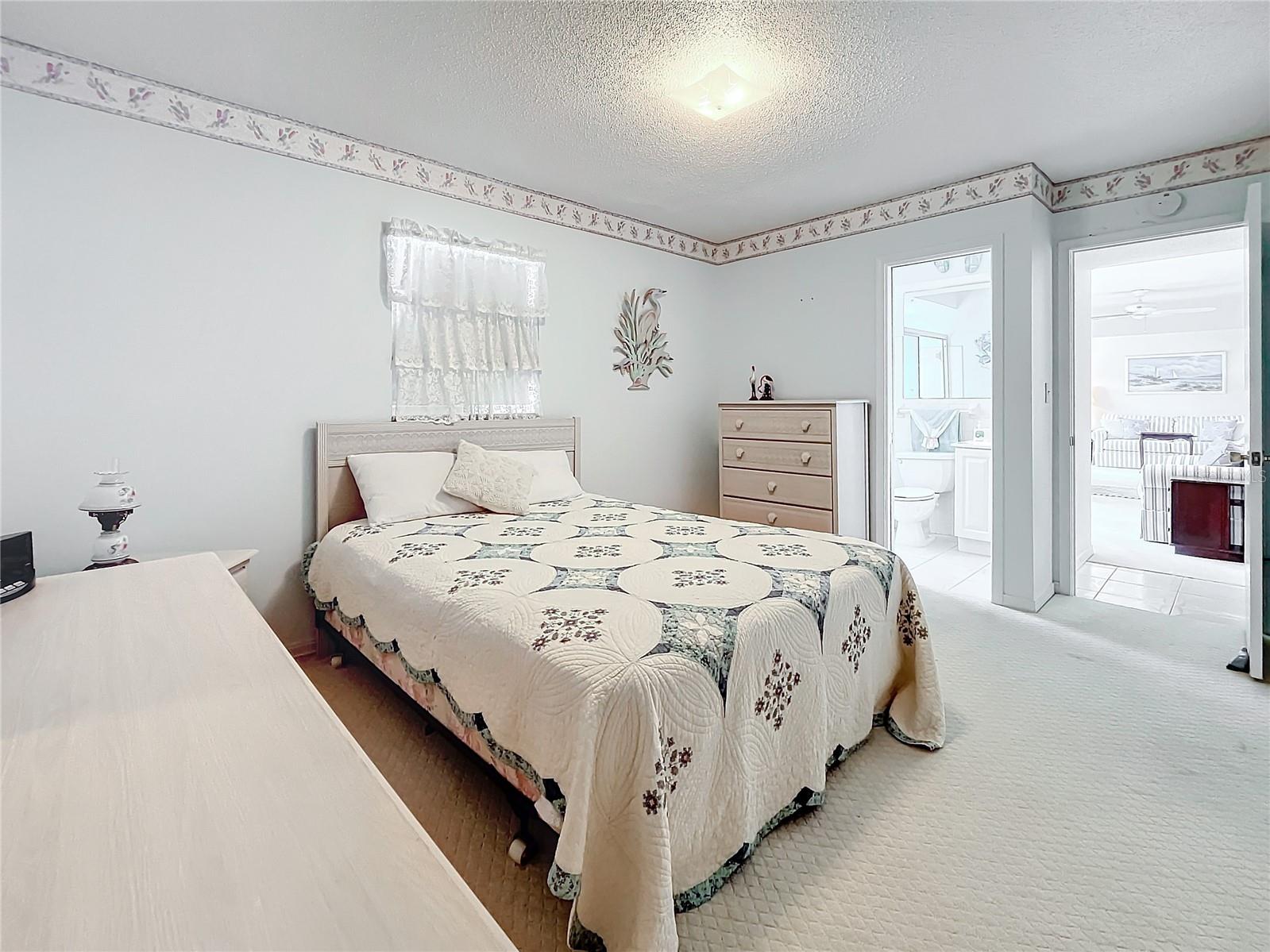 Primary bedroom in different angel toward the primary bathroom