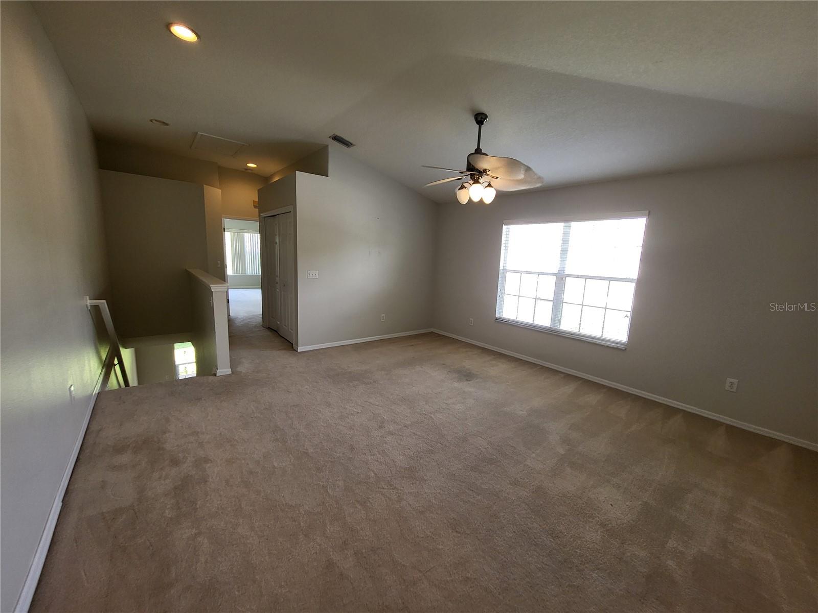 View to back of unit shows hallway to Primary Suite featuring the laundry closet & a linen closet