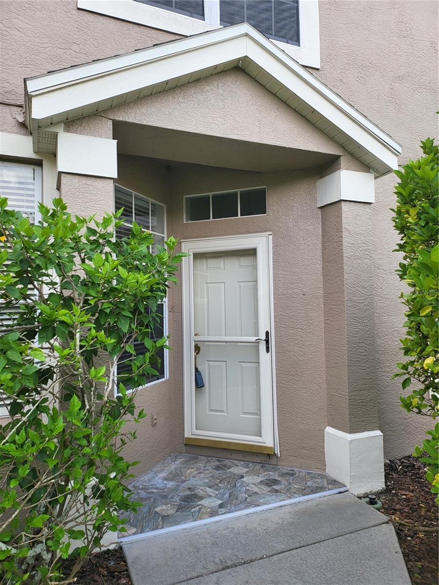 Covered entry features a glass storm door