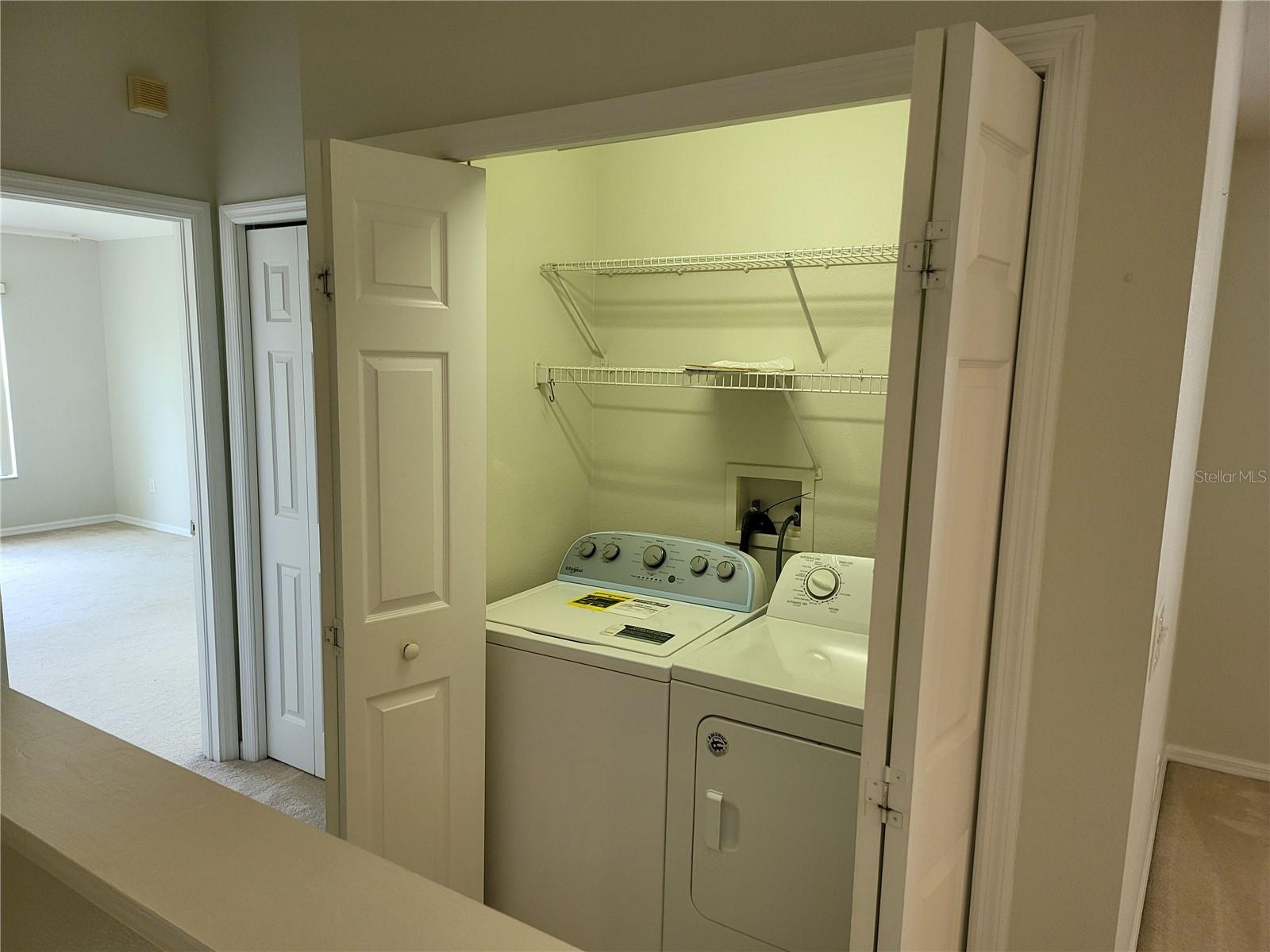 Laundry closet with built in light features Full Size Washer & Dryer included.