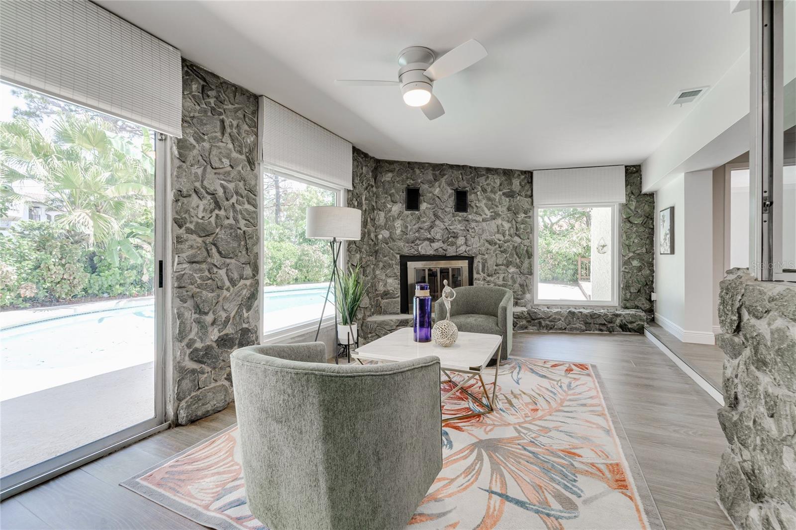 This room is one of a kind. The dining room, living room, and kitchen all overlook it and flow into it. With a cozy fireplace and unbeatable pool views - the potential is endless!