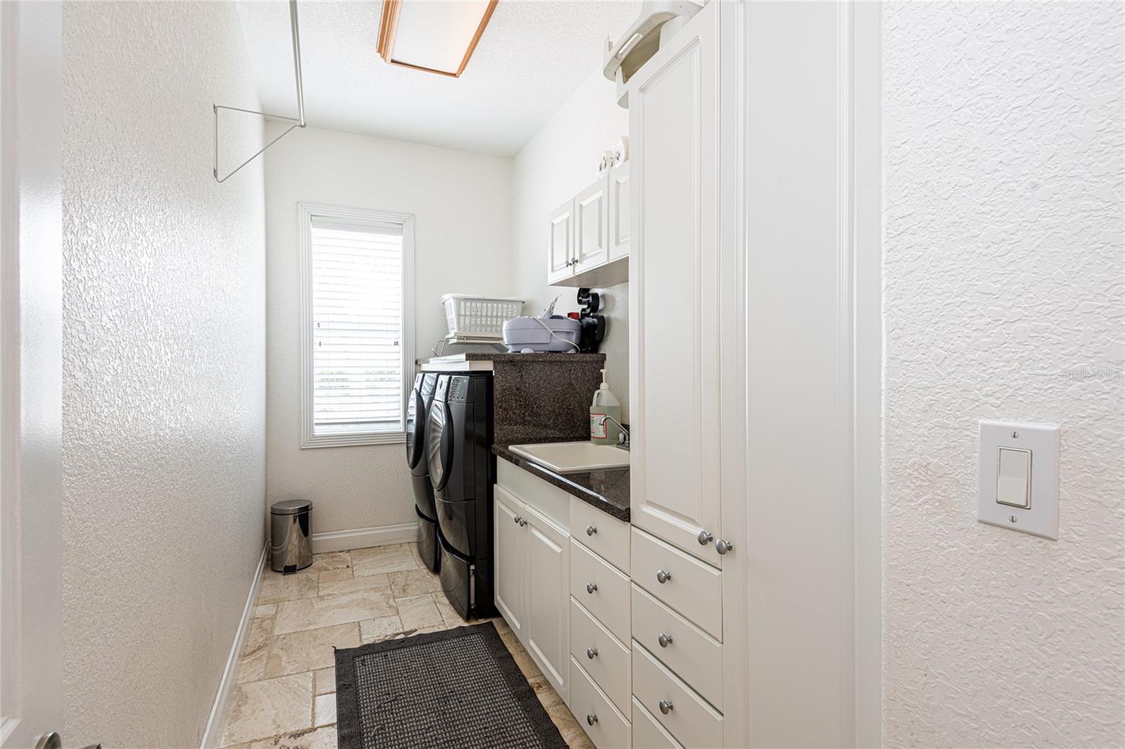 Large laundry room with lots of cabinet/drawer storage space for vacuum and  brooms.