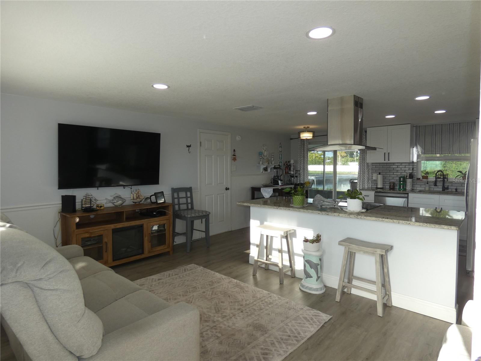 Living room, kitchen with breakfast bar and dining table looking directly out to the water..