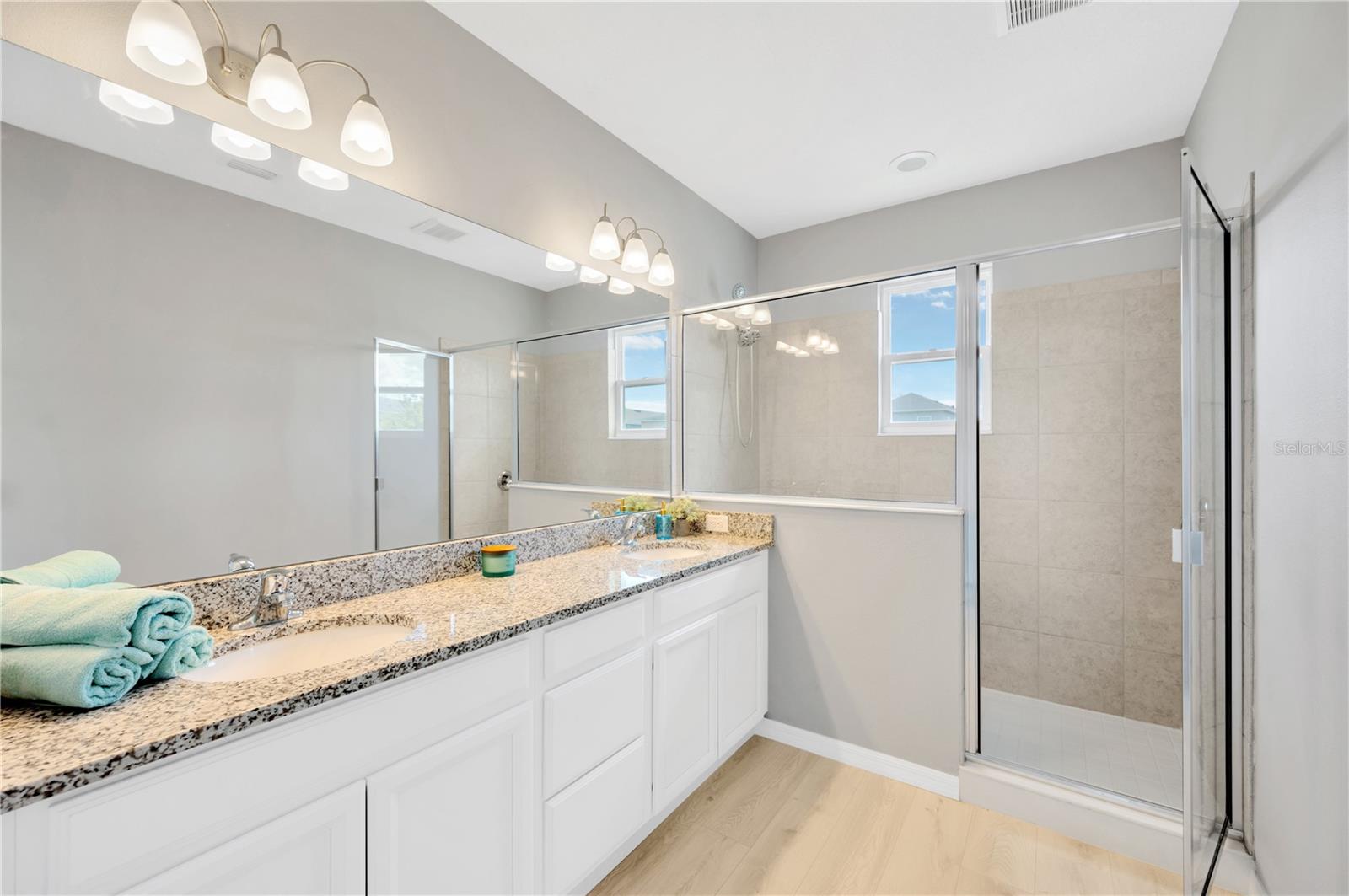 Dual sinks with ample counter space and walk-in shower