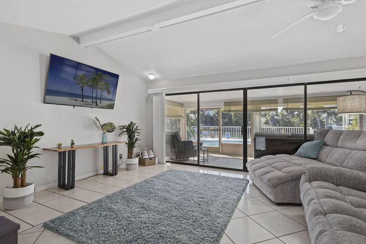 Vaulted Ceiling Living Room with Sliders going out to the Pool Area