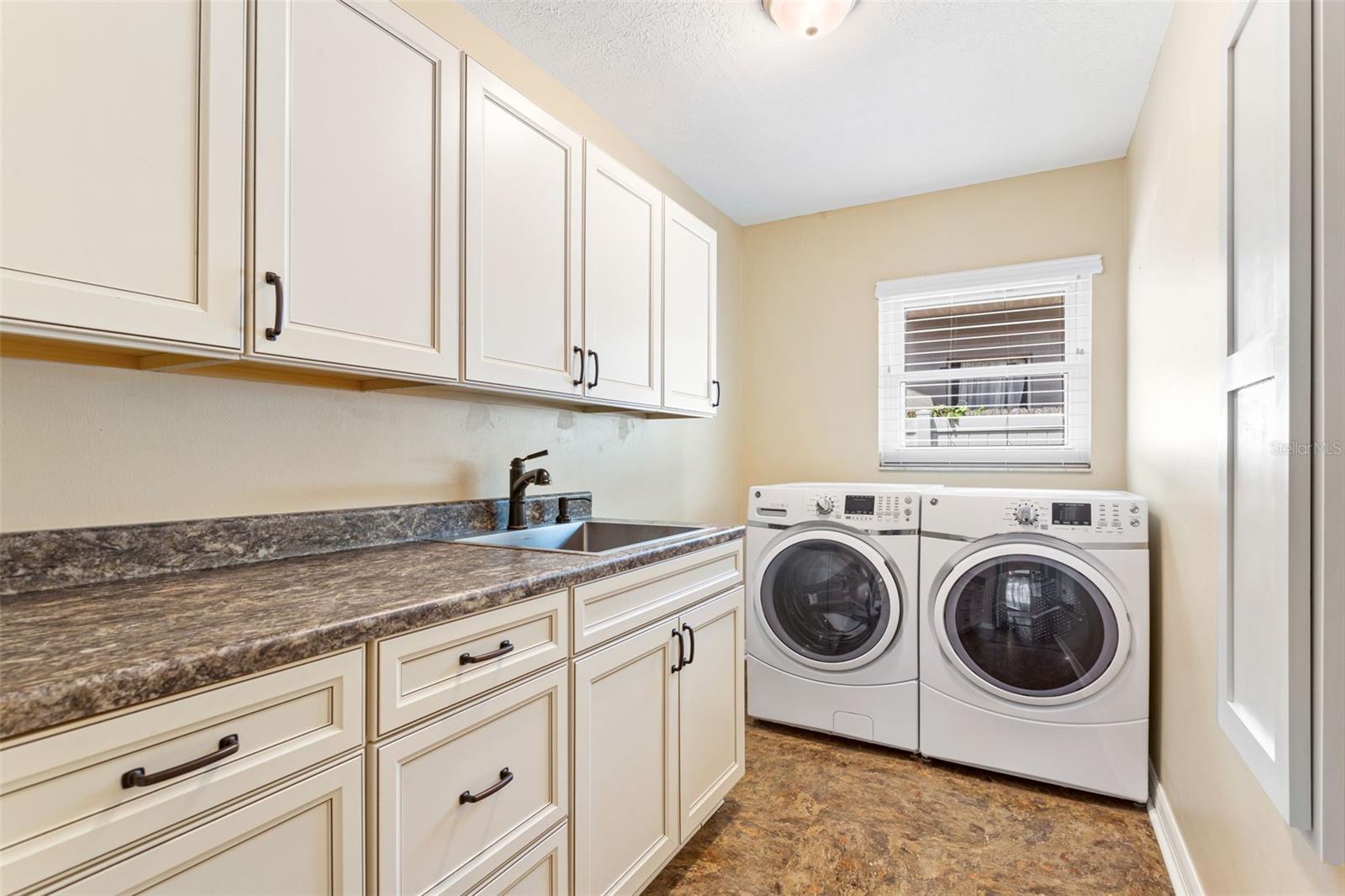 Inside Laundry Room w newer sink, ironing board & cabinets