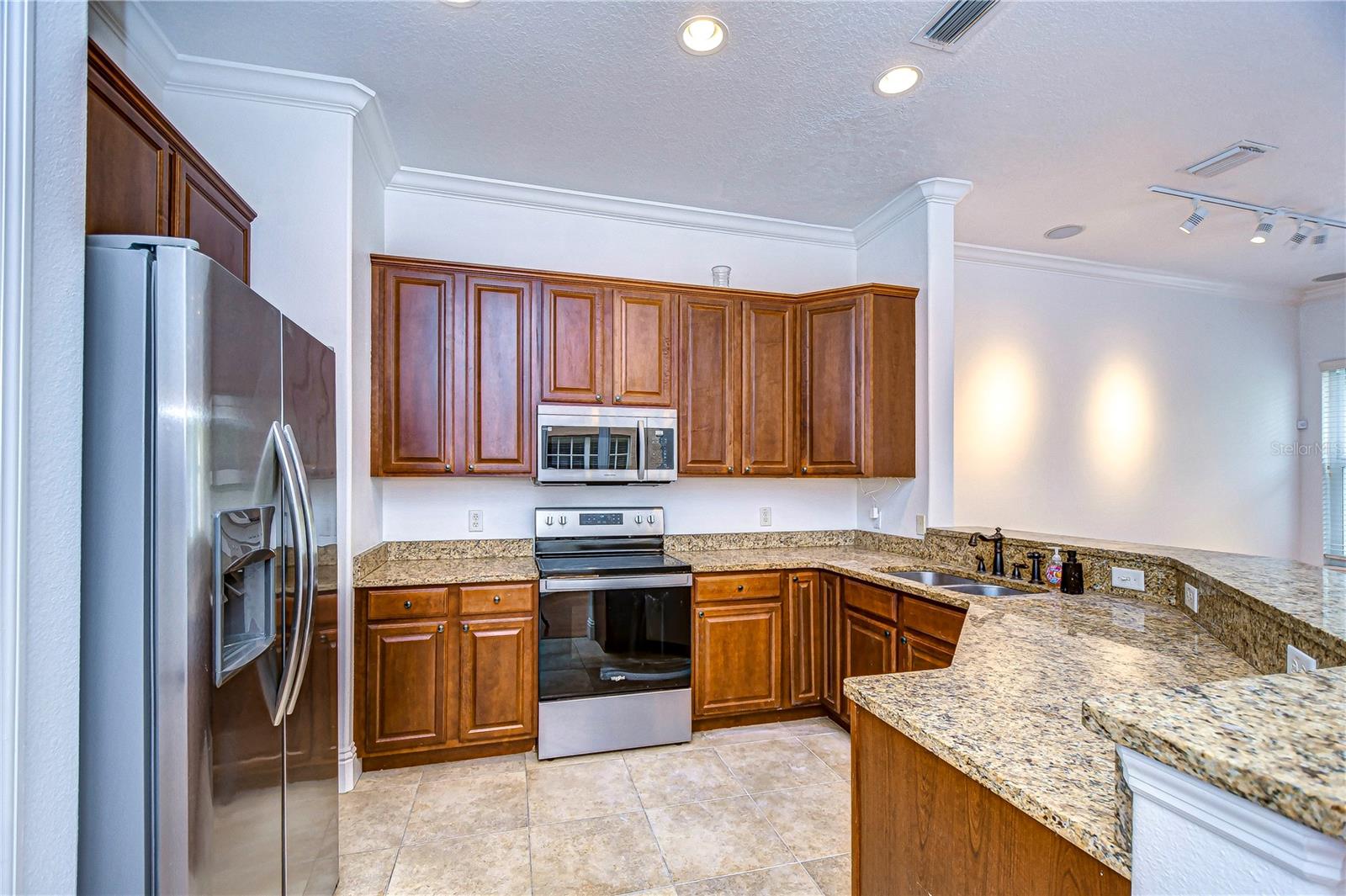 Rich dark wood cabinetry, gleaming granite countertops, and stainless appliances!