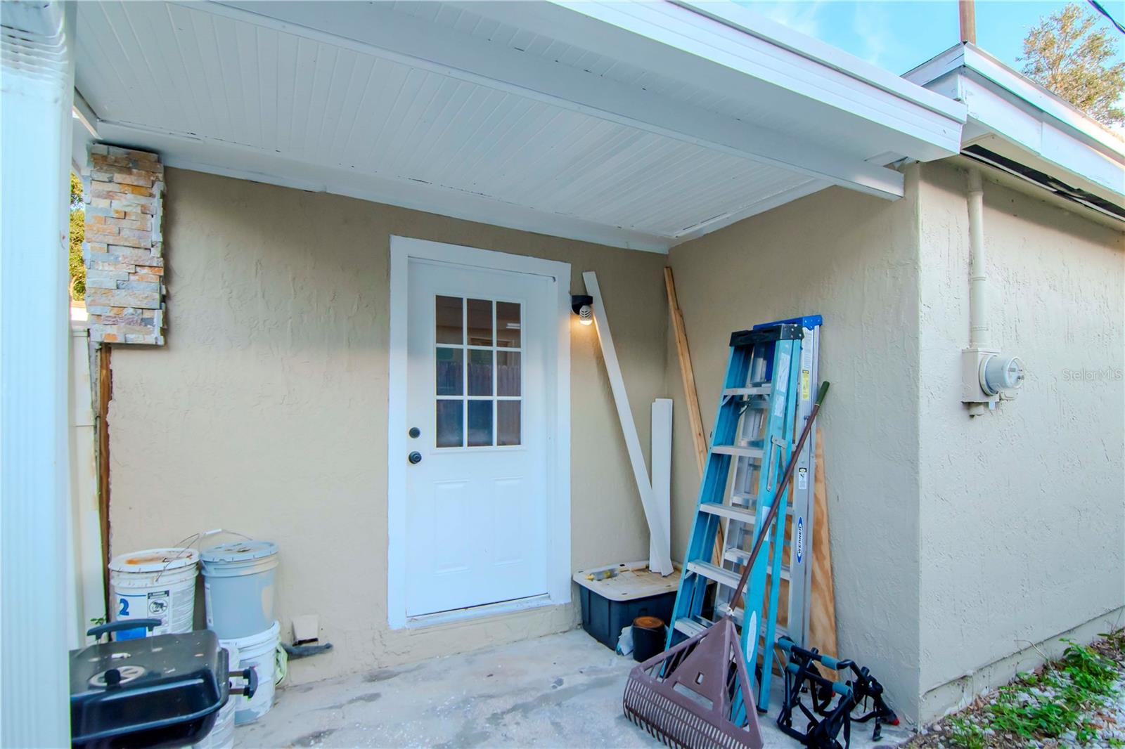 Side entrance to laundry room is tucked safely behind a gate for privacy.