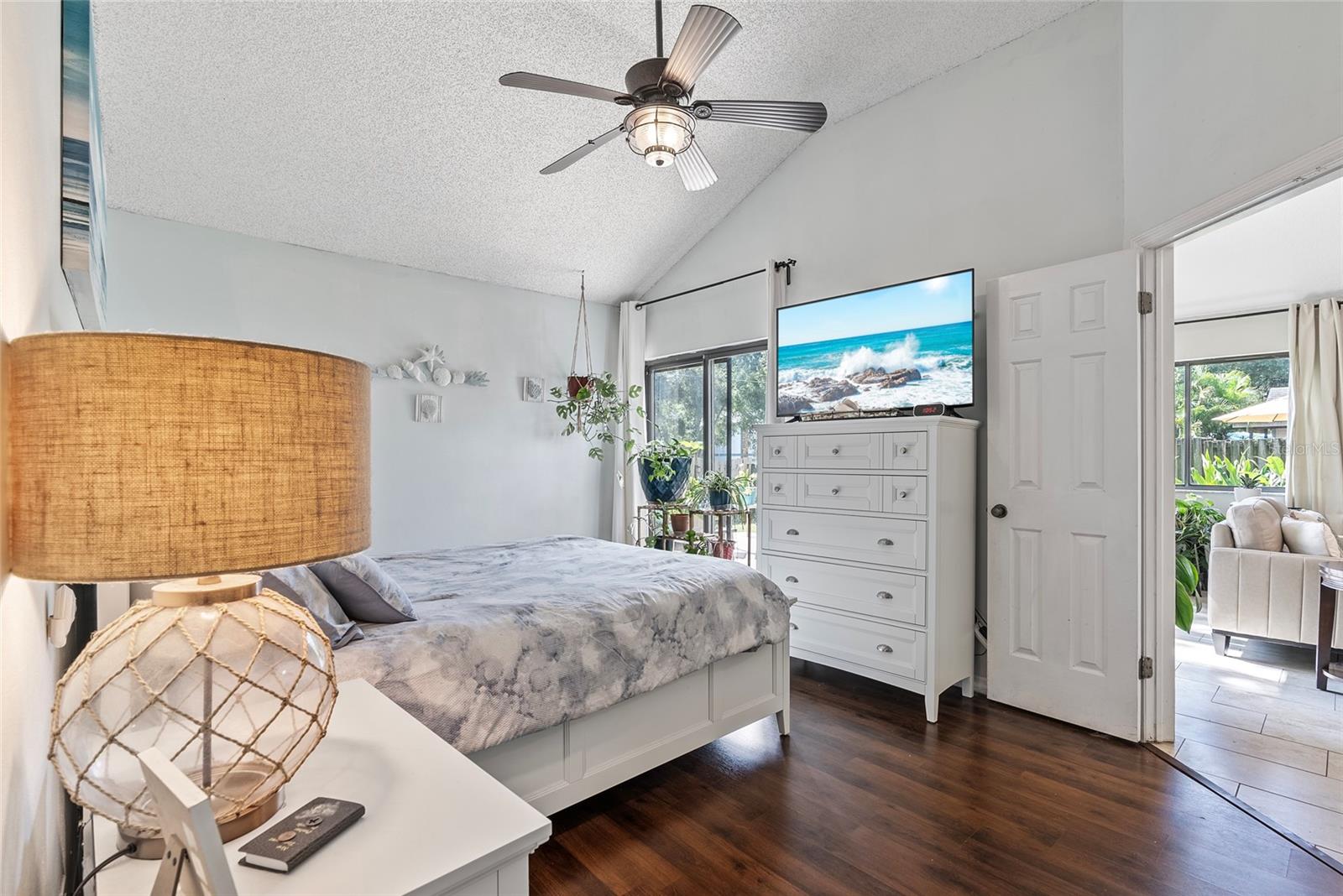 Alternate view of the primary bedroom with sliders to the backyard on the left and entrance to the living room on the right.