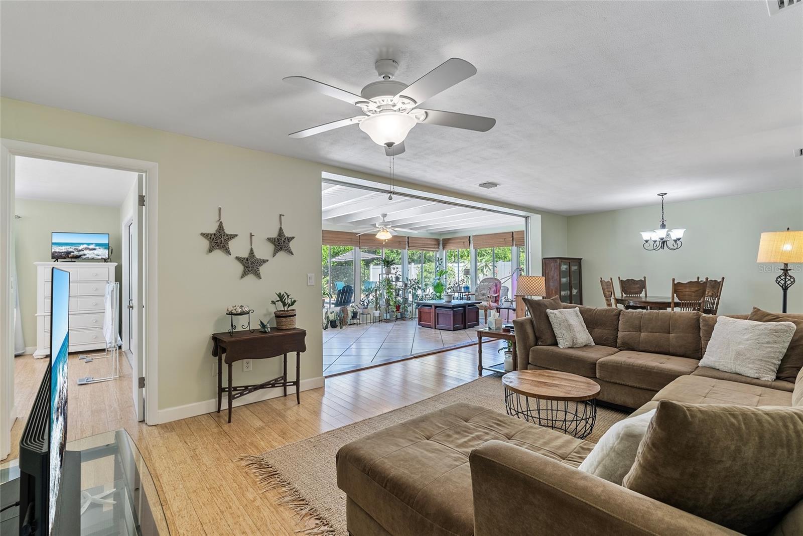 Living Room + Bonus/Sunroom.  Door to the left of the bonus room leads to primary suite