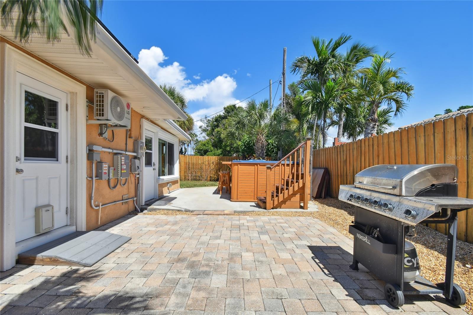 Another papered patio and grilling area next to the spa.  Extra door into the laundry room, kitchen  and main house. Door with doggie door, and windows that open for gentle cross breezes when desired.