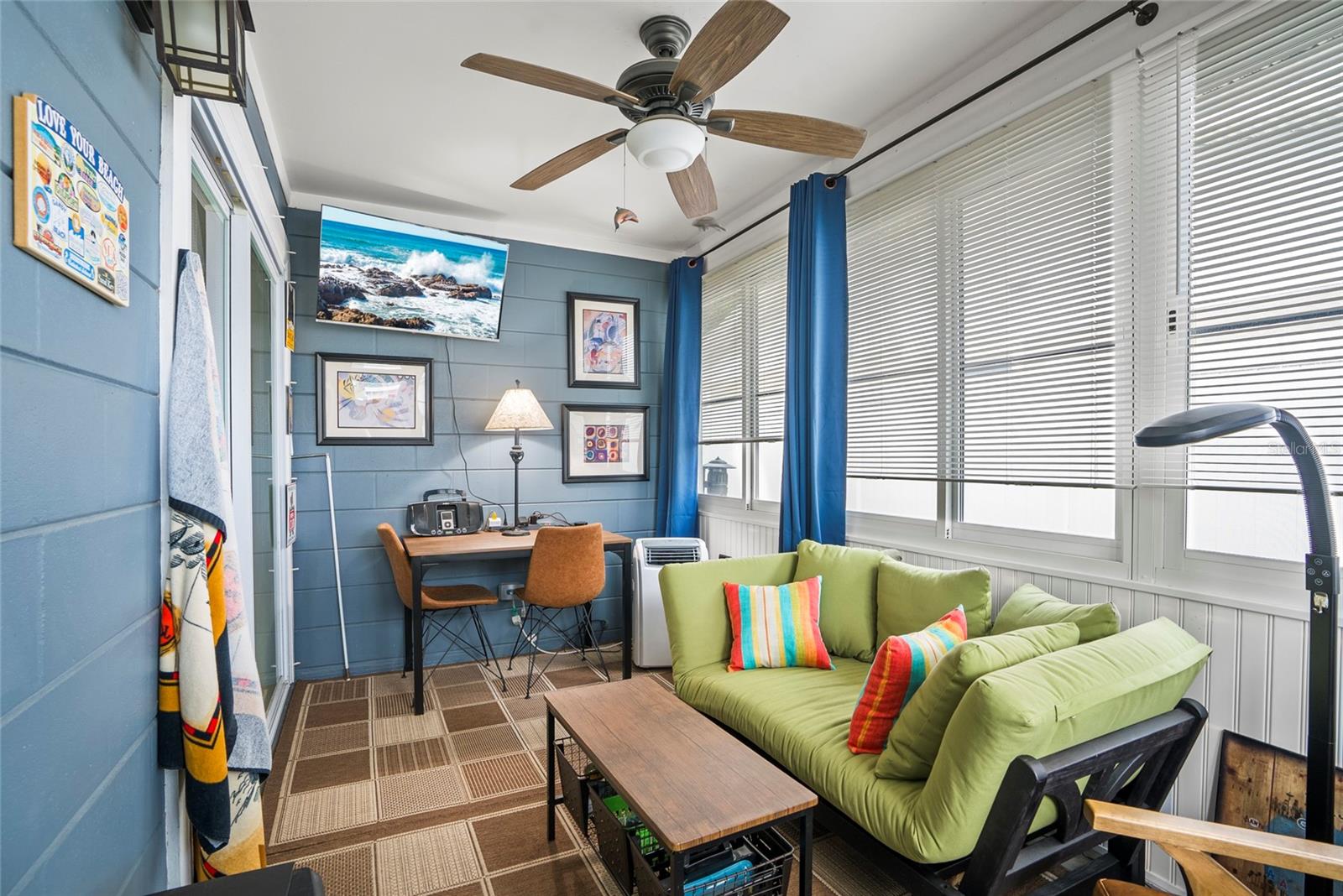 Sun room with portable AC and mounted TV.