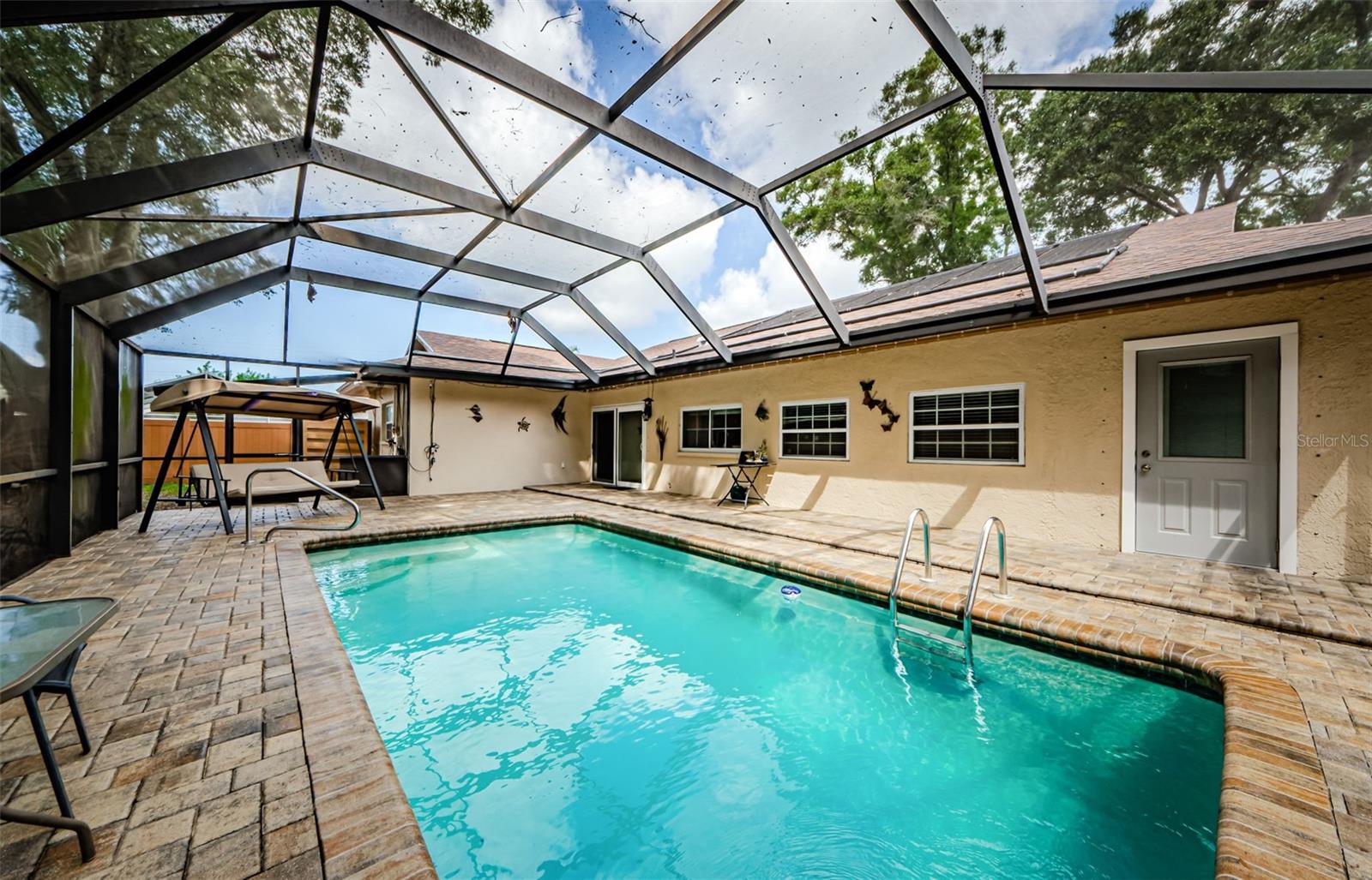 LARGE SCREEN ENCLOSED POOL WITH BRICK PAVERS