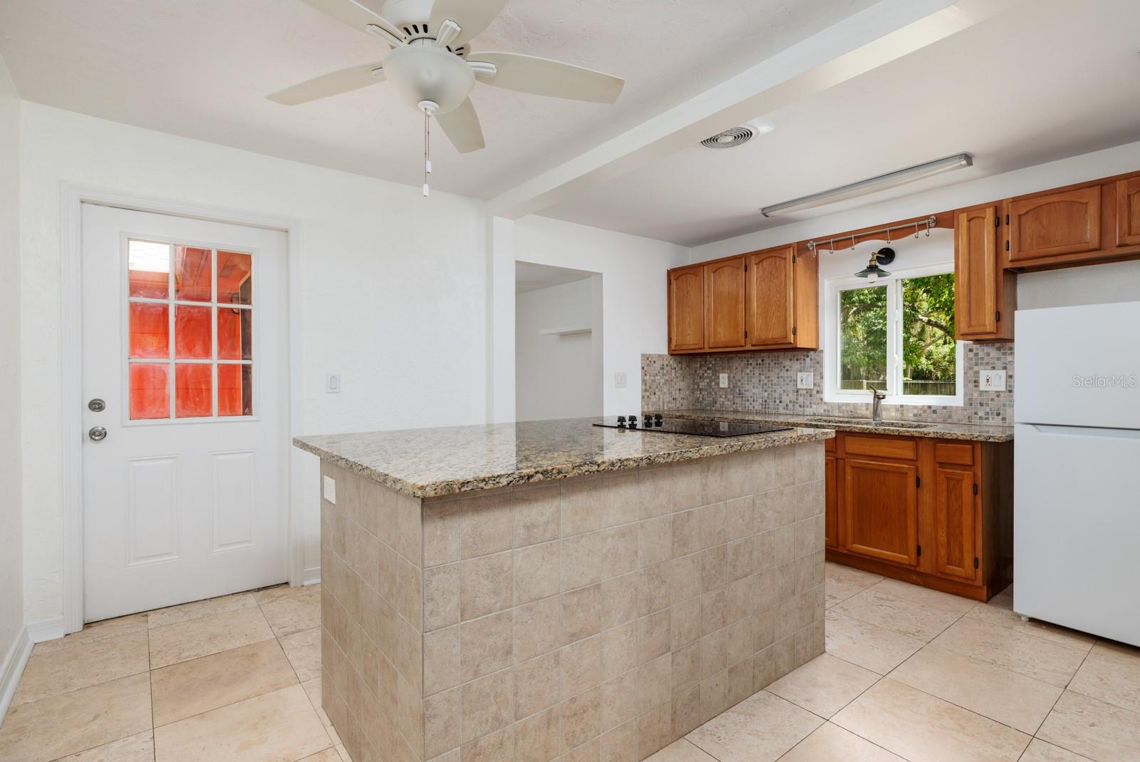 Kitchen renovated 2017. Door to back porch & other door to bonus room & garage. 2017 appliances except 2024  garbage disposal/sink faucet & 2022 refrigerator.