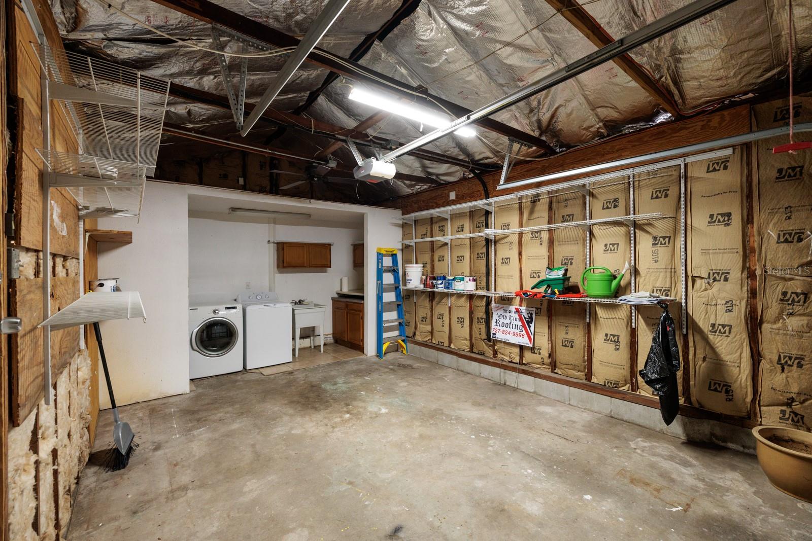 Insulated garage. Laundry room with cabinets & shelving. Storage loft above laundry room.