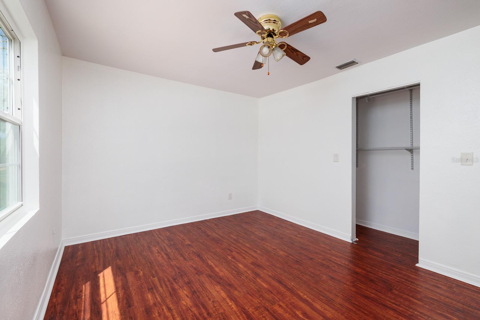 Primary bedroom w/laminate flooring & built in closet.