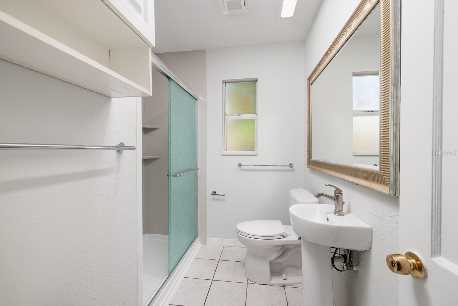 Bathroom w/Shower & exhaust fan, single pane window w/Hurricane impact screen. New pedestal sink 2022.