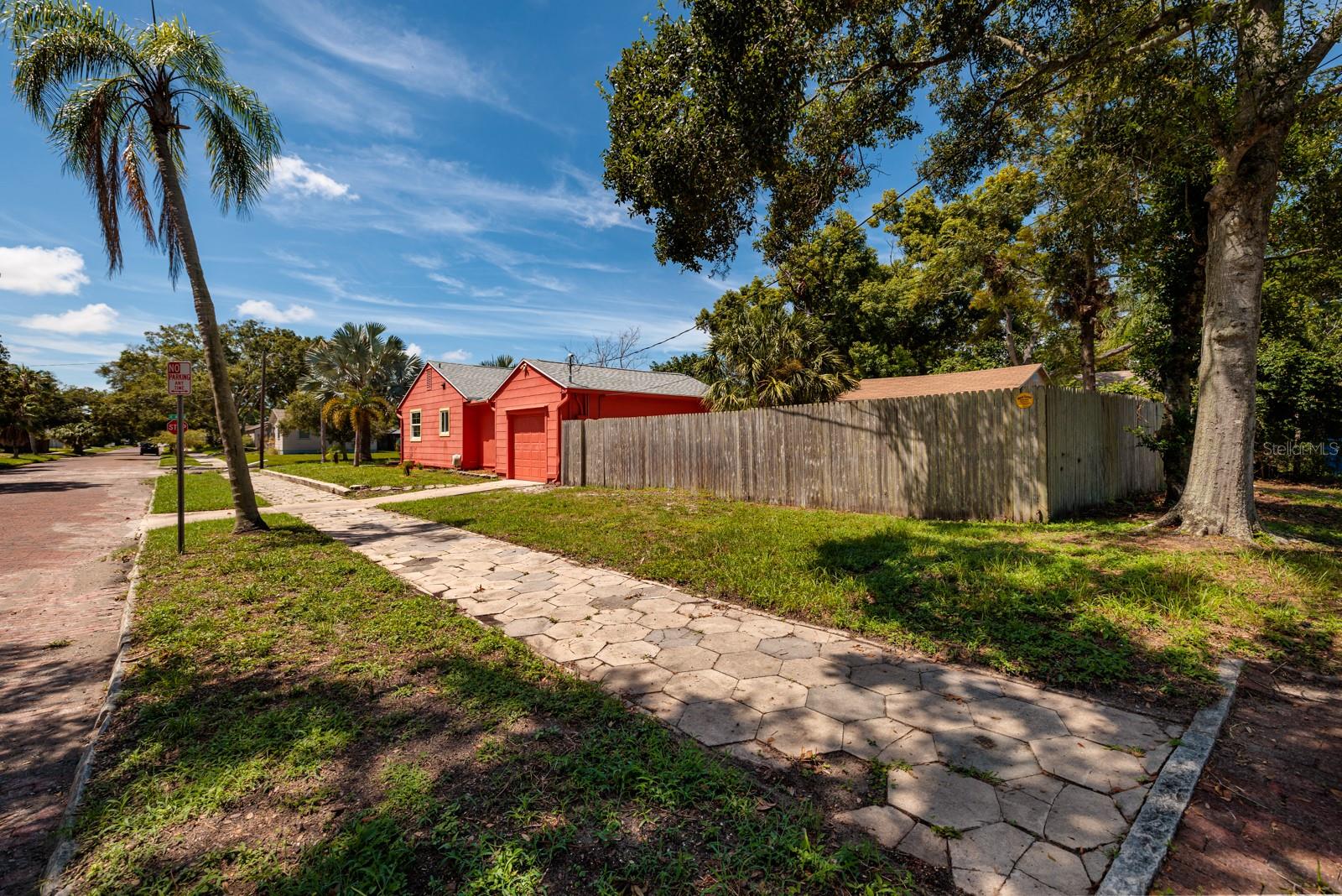 Side of house w/driveway to garage. Corner lot. Wood fence. Paver sidewalk. Brick streets.