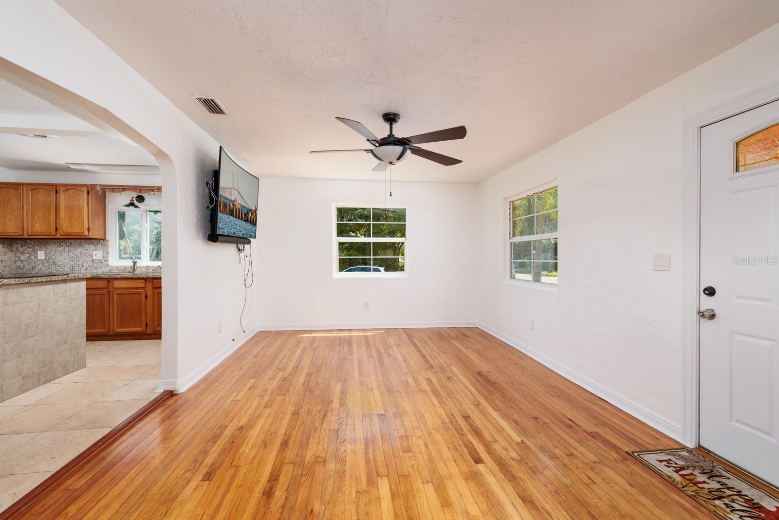 Living/dining room. 2017 Hurricane impact double pane windows. Wood flooring.