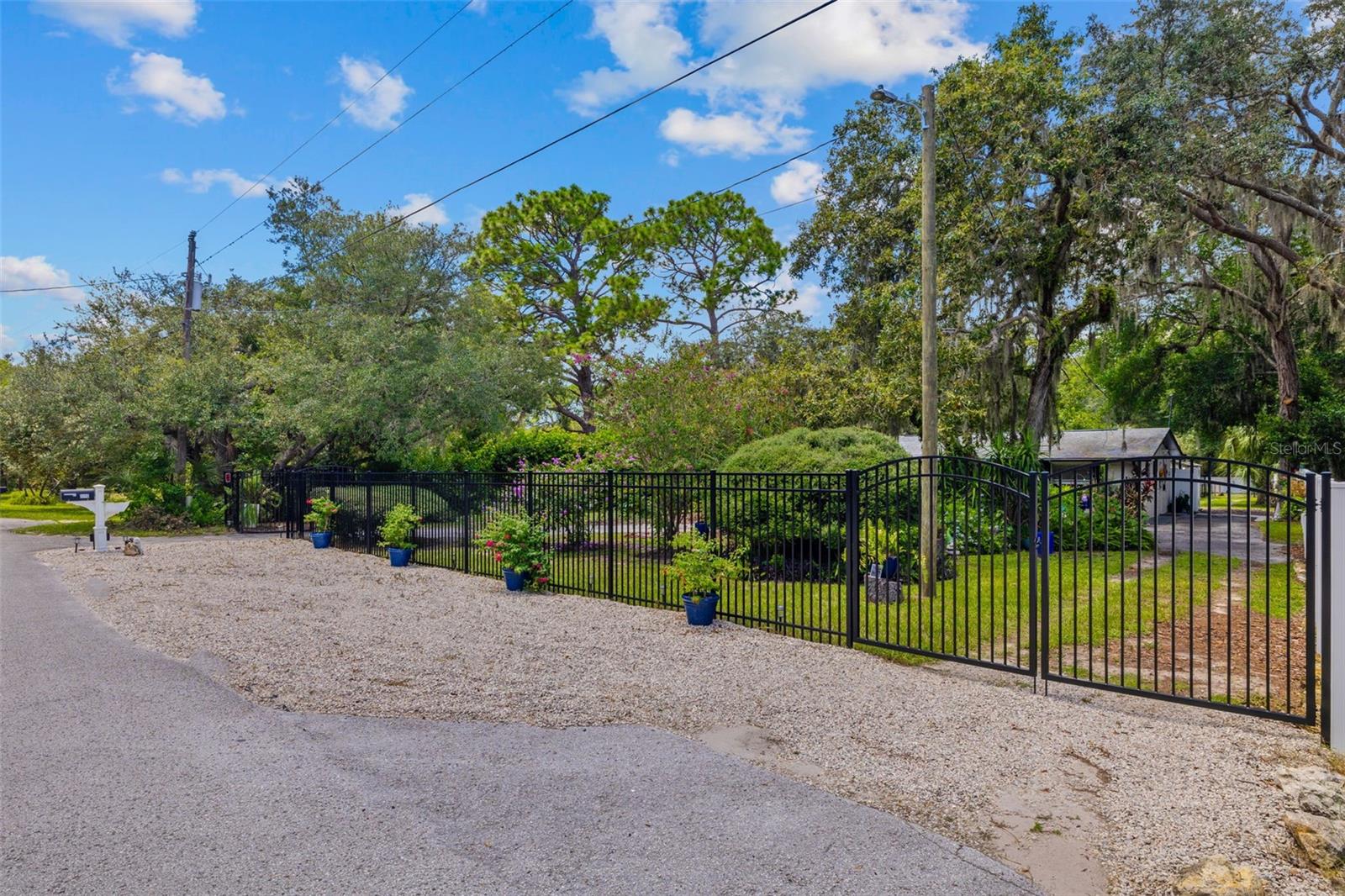 Privacy fencing along front of property, double gates with circular driveway