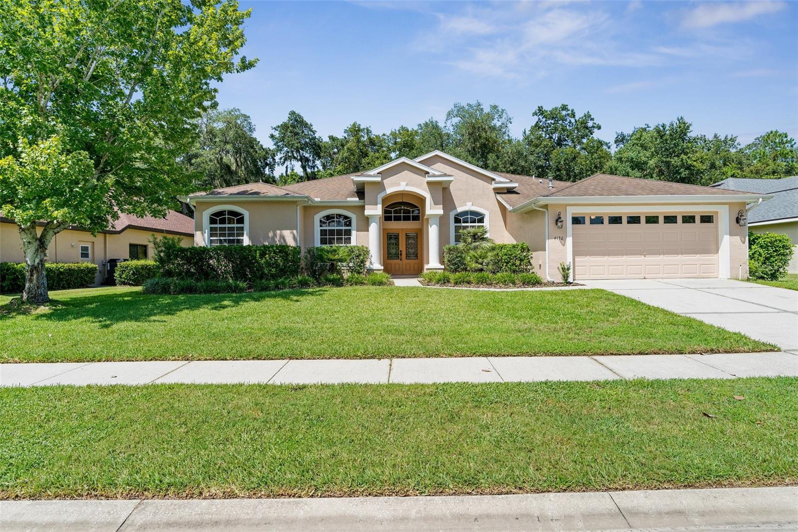 Gorgeous grand entrance, lush lawn and landscaping, great curb appeal.