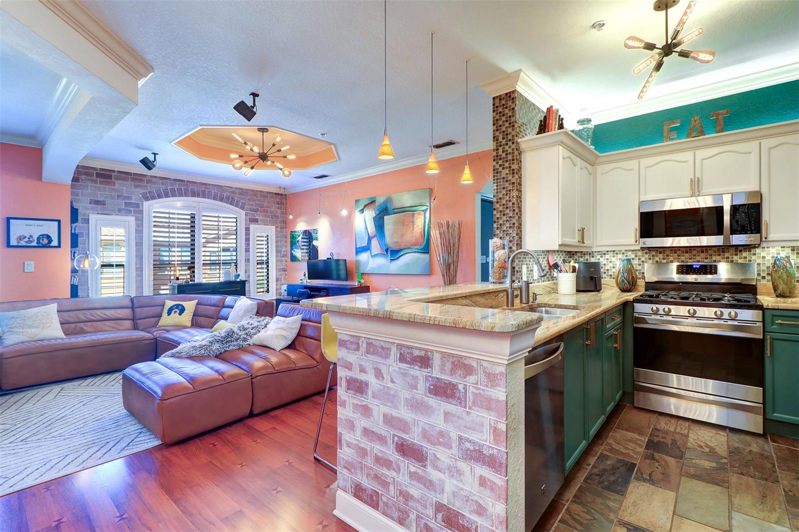 Interior view of fully equipped efficient chef kitchen and breakfast bar adjacent to large open living area