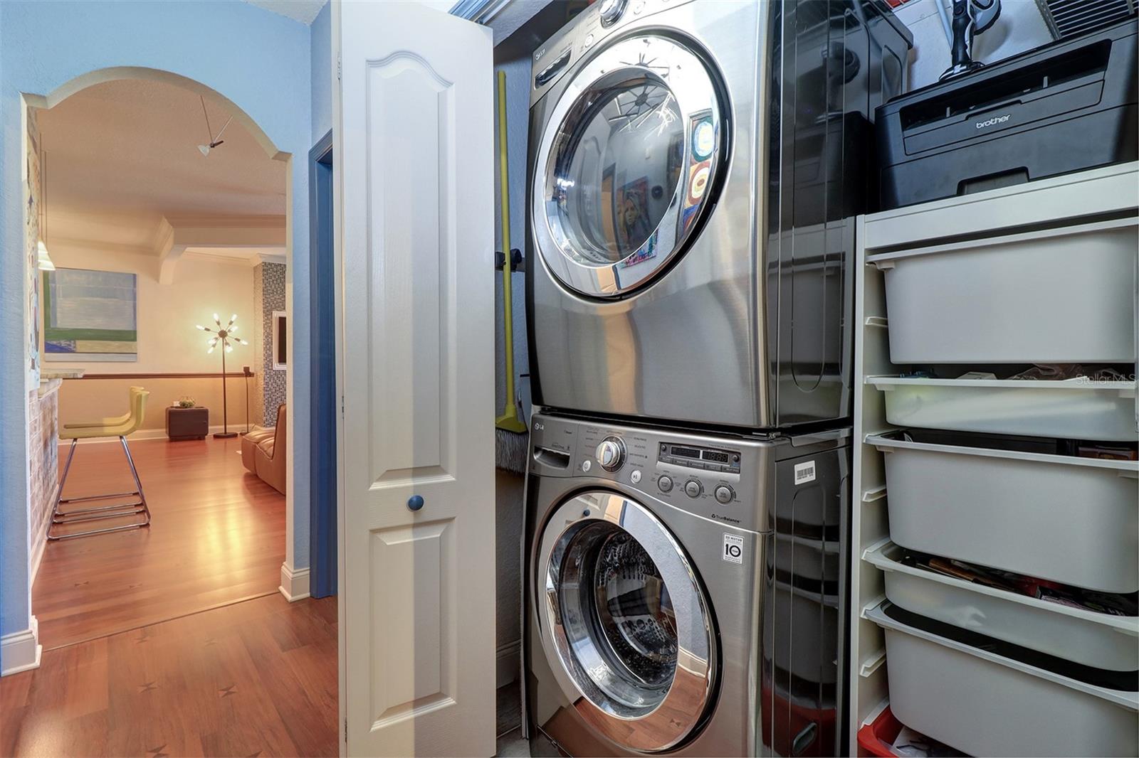 Laundry closet with stackable full size washer and dryer and interior cabinet shelving