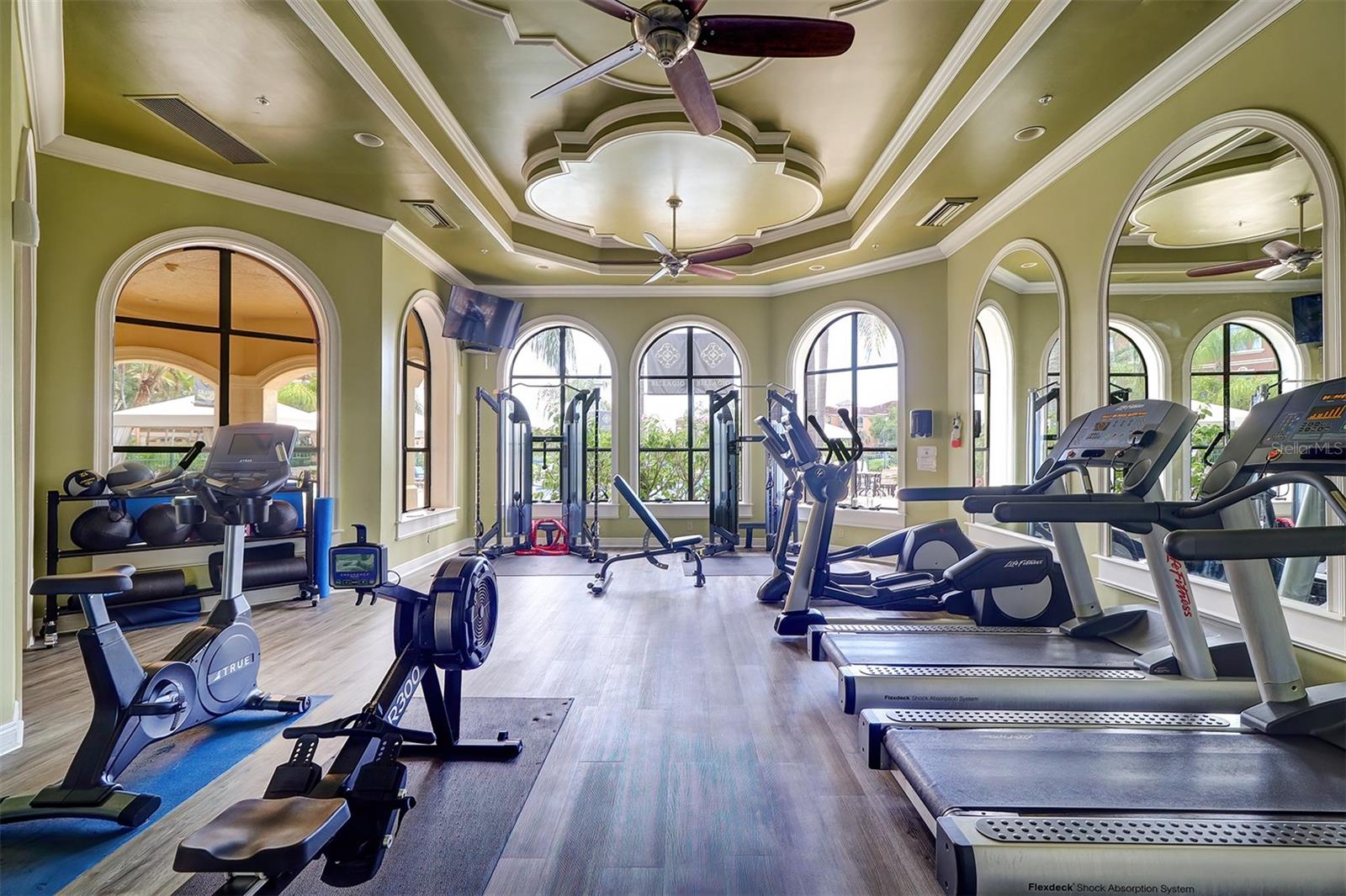 Fitness center inside the clubhouse looking out over the pool and spa