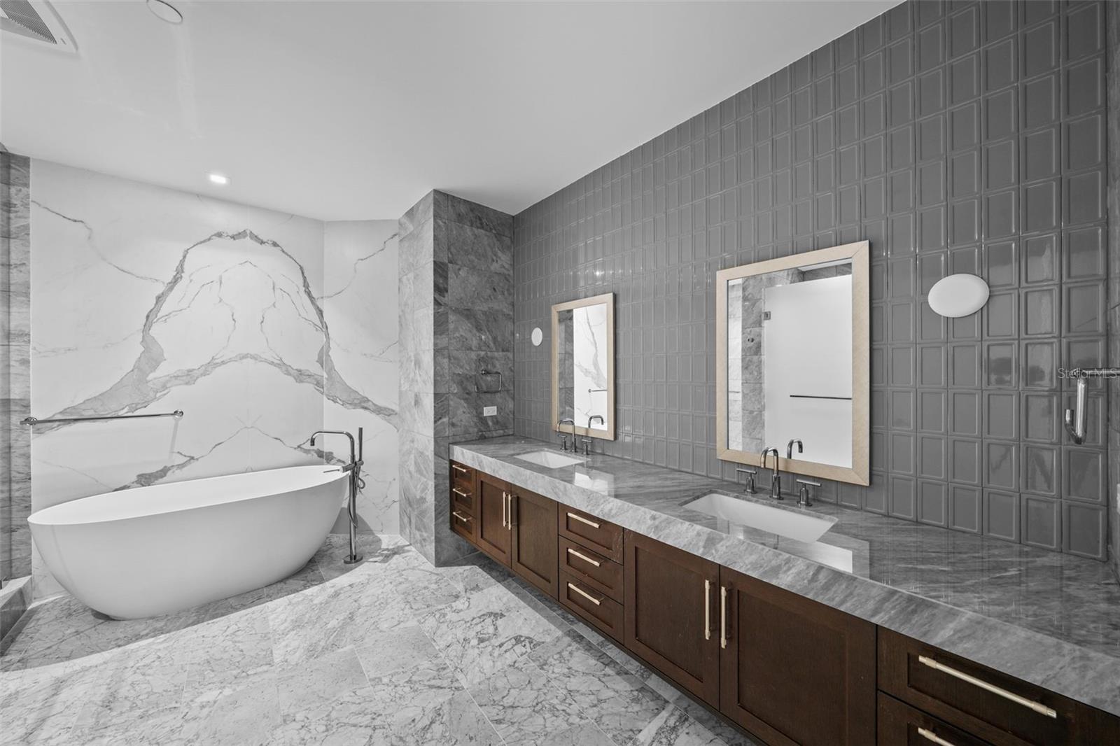 Vanity & soaking tub with a wall of granite