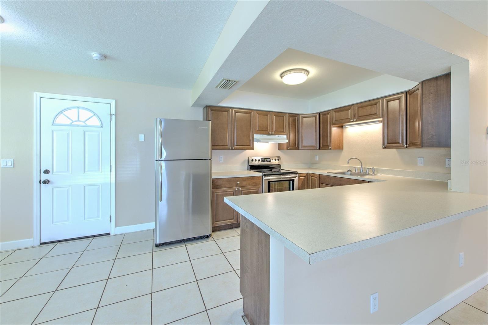 Kitchen with view from living room, dinette with view to the front door and flex space to the left