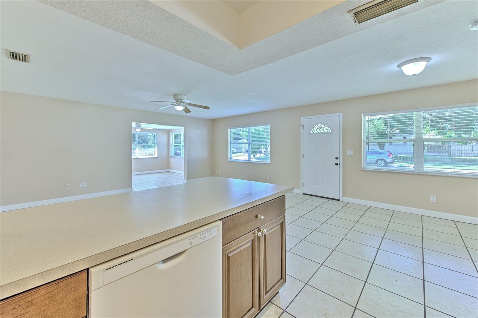 Kitchen with view from living room, dinette with view to the front door and flex space to the left