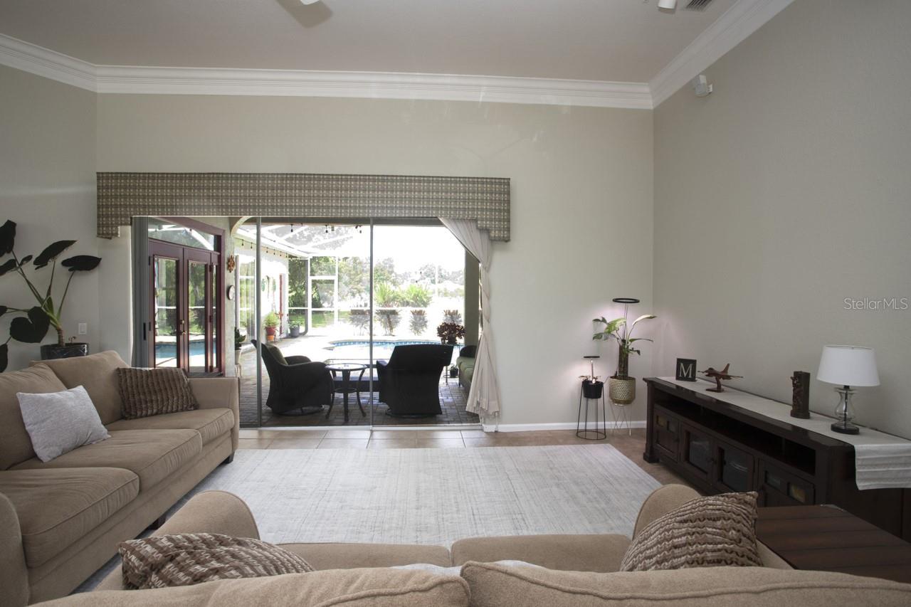 Open and airy Living Room and view of the covered lanai and screened pool