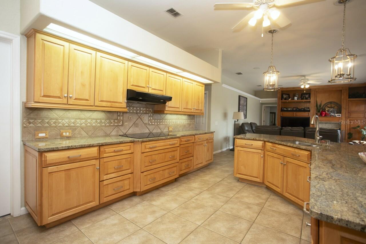 Smooth stove top, tiled back splash, all wood Kitchen cabinets & drawers, left view