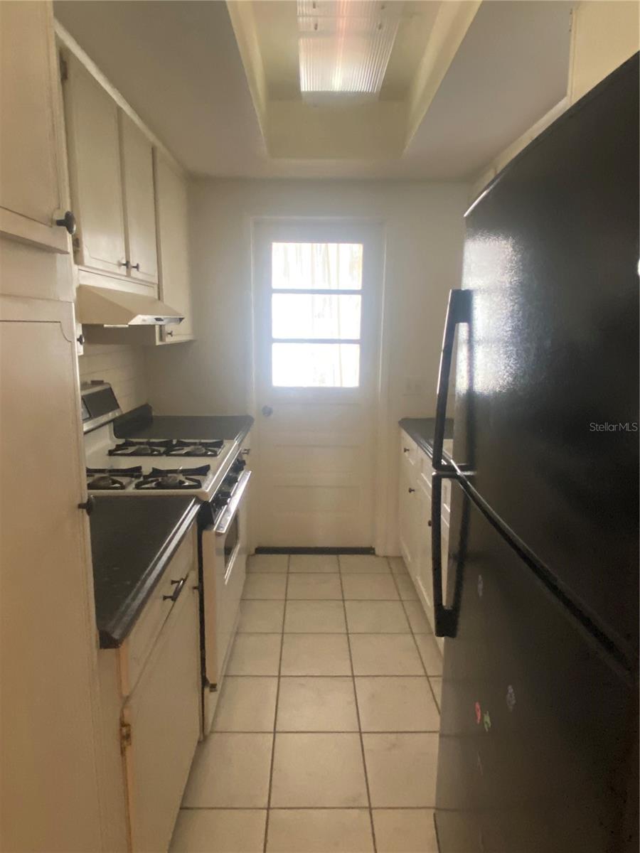 You are in the hall, storage & HVAC to your right. View into kitchen. Lower right cabinets have been updated.