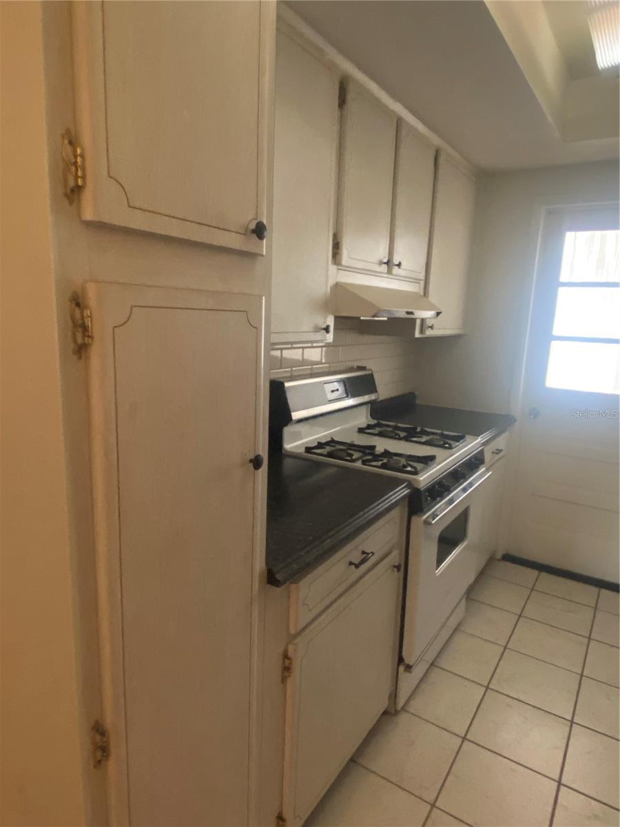 You are in the hall, storage & HVAC to your right. View into kitchen. Gas range.