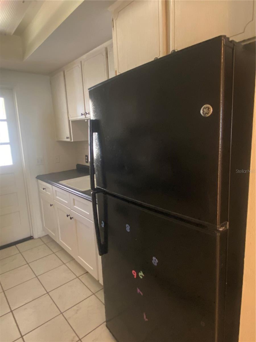 You are in the hall, storage & HVAC to your right. View into kitchen. Lower cabinets have been updated.