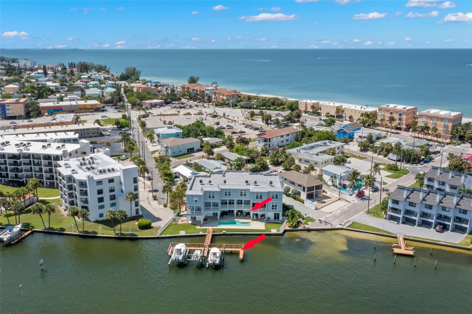 Location, location, location! This aerial view highlights your townhome's prime spot right on the Intracoastal Waterway, complete with a private balcony and deeded boat slip, just steps away from the Gulf beaches.