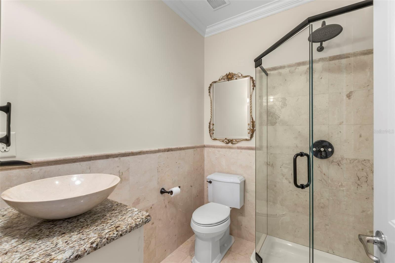 Conveniently located between the main living area and the versatile third bedroom, this stylish full bath features a glass-enclosed shower and elegant vanity, perfect for guests and everyday use.