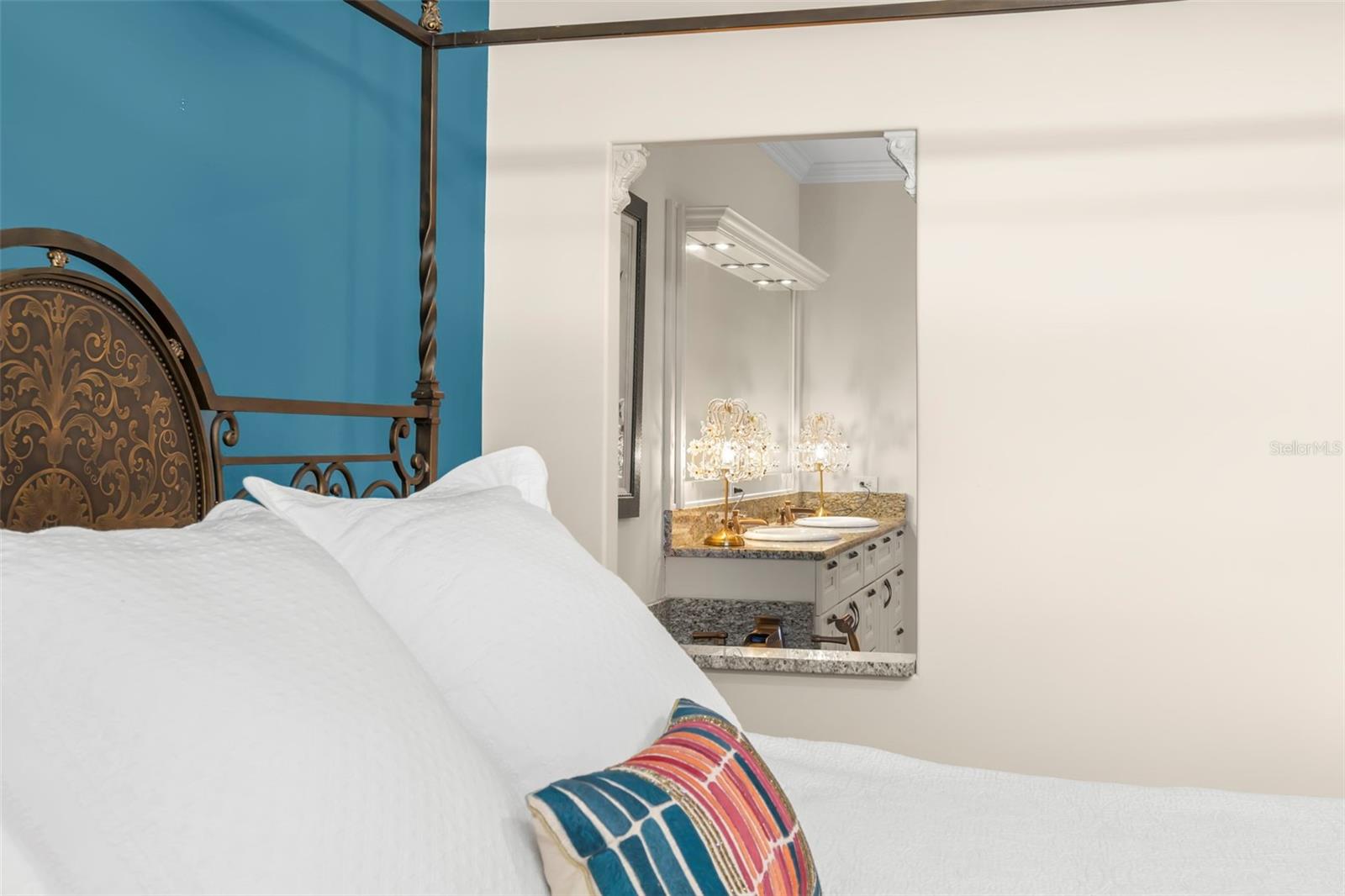 A peek from the primary bedroom into the en suite bath, where elegance meets comfort with granite counters and warm lighting.