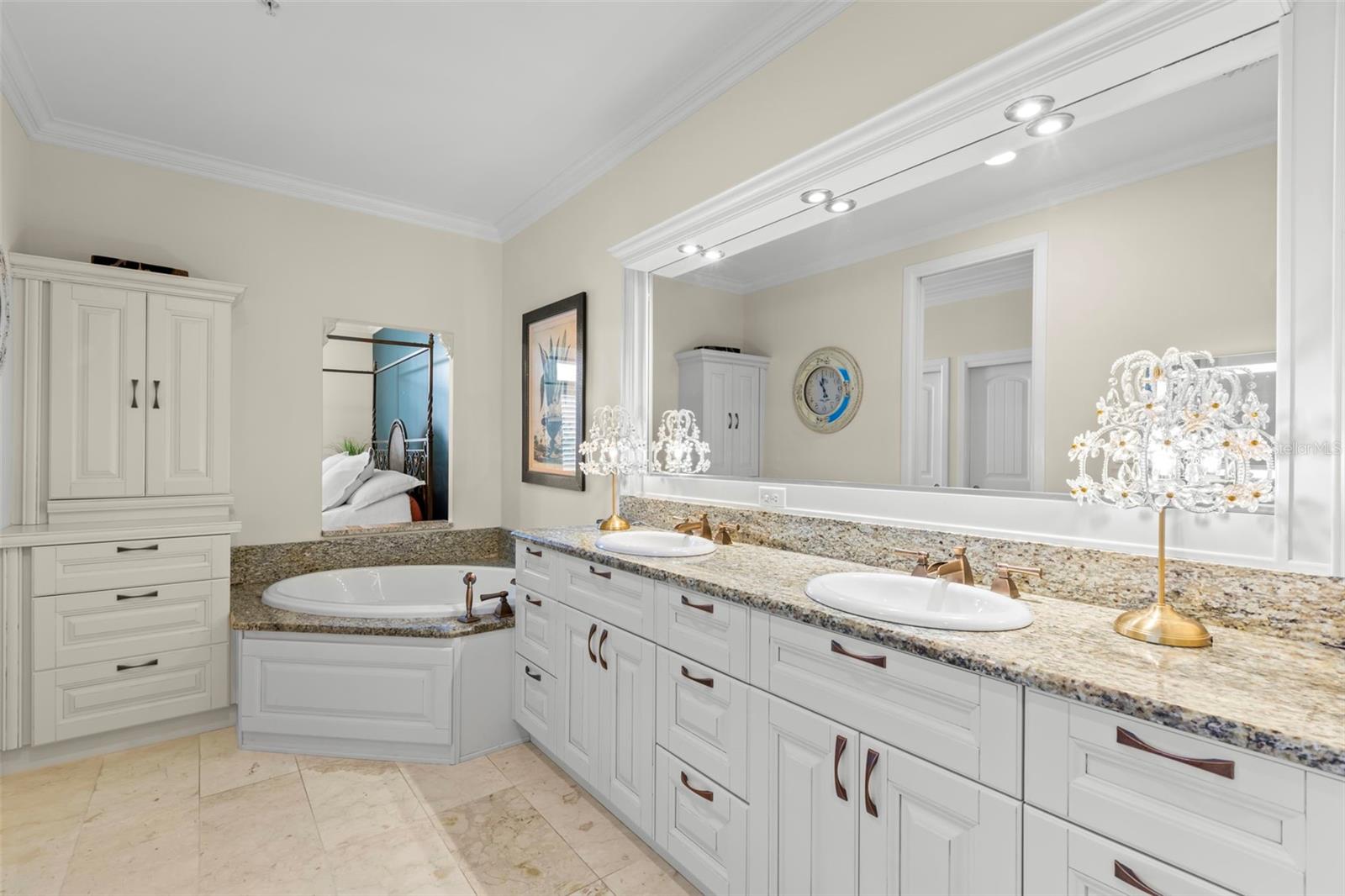 Luxurious en suite bath featuring double sinks, a soaking tub, and ample counter space, perfect for unwinding in style.