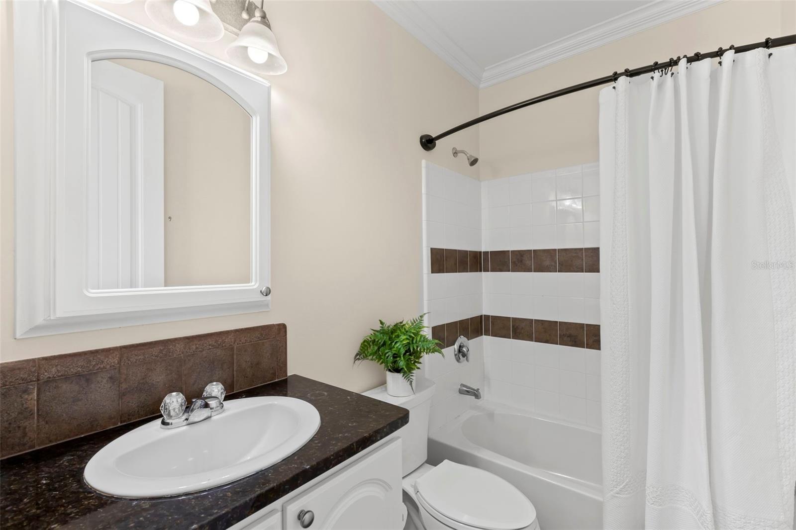 Bright and clean guest bathroom with a shower and tub combination, perfect for unwinding after a day of exploring.